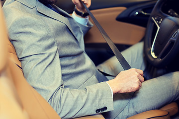 Image showing close up of man fastening seat safety belt in car