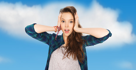 Image showing happy pretty teenage girl holding to head