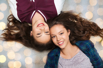 Image showing happy smiling pretty teenage girls lying on floor