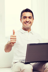 Image showing happy man working with laptop computer at home