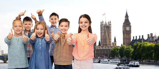 Image showing happy children showing thumbs up over london