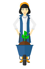 Image showing Woman with plant and wheelbarrow.