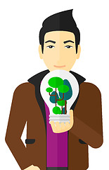 Image showing Man with lightbulb and trees inside.