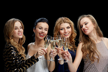 Image showing happy women clinking champagne glasses over black