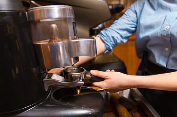 Image showing close up of woman making coffee by machine at cafe