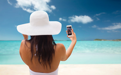 Image showing woman taking selfie with smartphone on beach