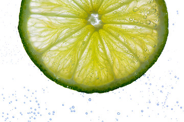 Image showing lime slice falling or dipping in water 