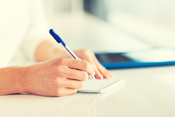 Image showing close up of hands with pen writing to notepad