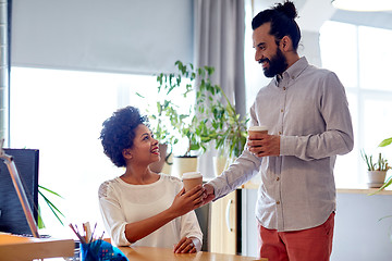 Image showing happy man bringing coffee to woman in office