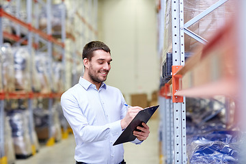 Image showing happy businessman with clipboard at warehouse