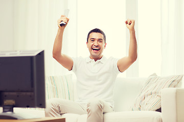 Image showing smiling man watching sports at home