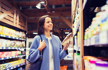 Image showing happy woman choosing and buying food in market