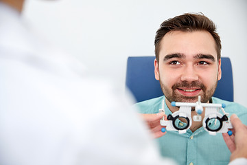 Image showing optician with trial frame and patient at clinic