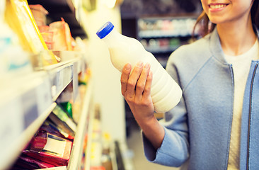 Image showing happy woman holding milk bottle in market