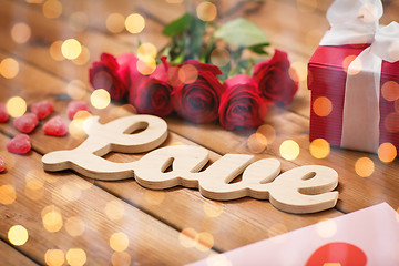 Image showing close up of gift box, red roses and greeting card