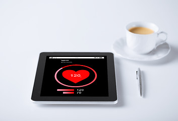 Image showing tablet pc with heart rate icon and cup of coffee