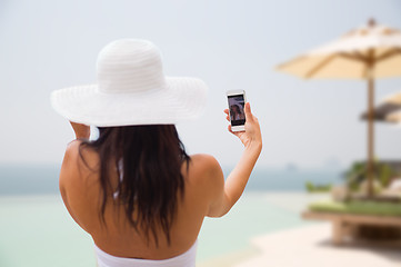 Image showing woman taking selfie with smartphone on beach