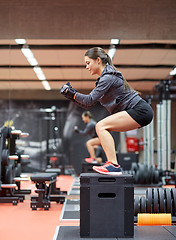 Image showing woman doing squats on pnatfom in gym