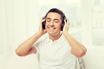 Image showing happy man in headphones listening to music at home