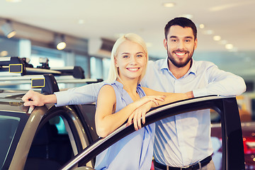 Image showing happy couple buying car in auto show or salon