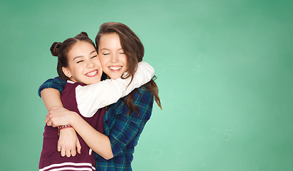 Image showing happy teenage girls hugging over green board