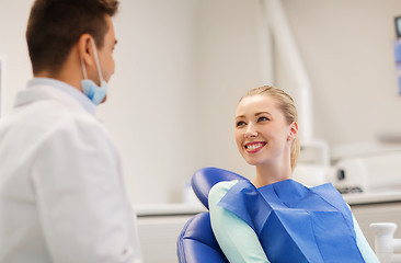 Image showing happy male dentist with woman patient at clinic