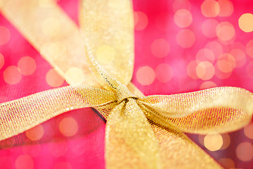 Image showing close up of golden bow on red gift box