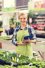 Image showing happy woman with tablet pc in greenhouse