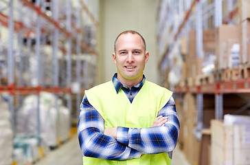 Image showing happy man in reflective safety vest at warehouse