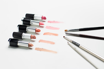 Image showing close up of lipsticks range with makeup brushes