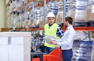 Image showing men with tablet pc and forklift at warehouse