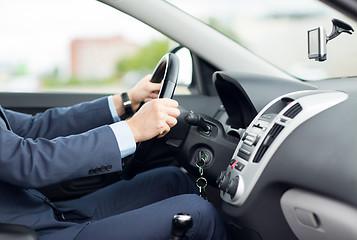 Image showing close up of young man in suit driving car