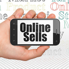 Image showing Advertising concept: Hand Holding Smartphone with Online Sells on display