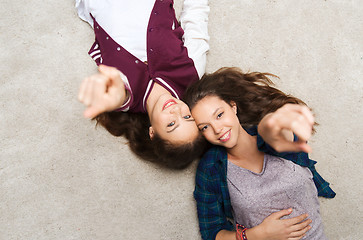 Image showing smiling teenage girls pointing finger to you