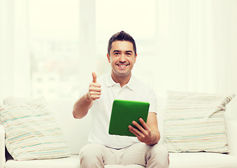 Image showing smiling man working with tablet pc at home