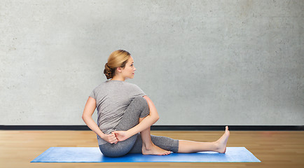 Image showing woman making yoga in twist pose on mat