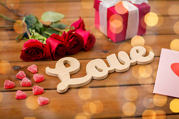 Image showing close up of gift box, red roses and greeting card