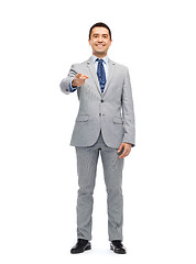 Image showing happy smiling businessman in suit pointing at you