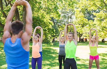 Image showing group of friends or sportsmen exercising outdoors