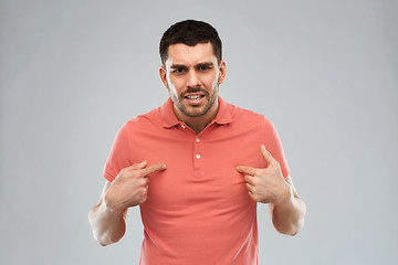 Image showing angry man pointing finger to himself over gray