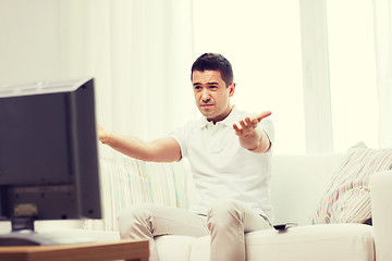 Image showing disappointed man watching tv at home