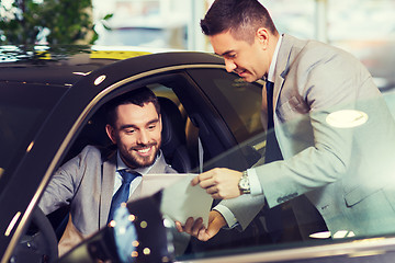 Image showing happy man with car dealer in auto show or salon