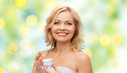Image showing happy middle aged woman with cream jar