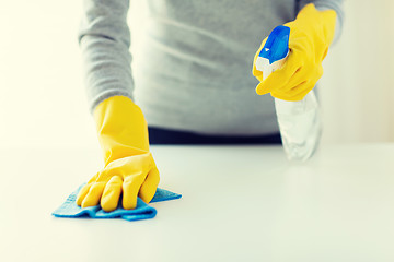 Image showing close up of woman cleaning table with cloth