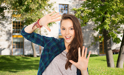 Image showing happy teenage student girl showing hands 