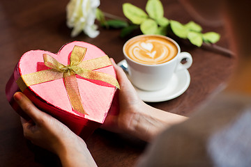 Image showing close up of hands holding heart shaped gift box