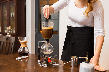 Image showing close up of woman with siphon coffee maker at shop