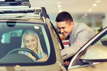 Image showing happy woman with car dealer in auto show or salon