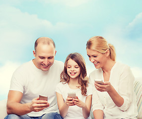 Image showing happy family with smartphones