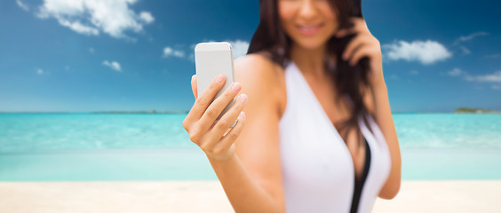 Image showing young woman taking selfie with smartphone on beach